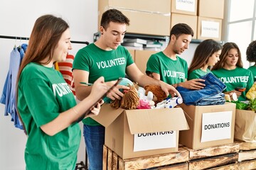 Group of young volunteers smiing happy working at charity center.