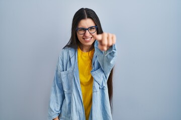 Poster - Young hispanic woman standing over blue background pointing displeased and frustrated to the camera, angry and furious with you