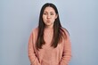 © Krakenimages.com - Young latin woman standing over blue background puffing cheeks with funny face. mouth inflated with air, crazy expression.