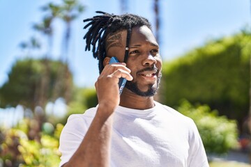 African american woman smiling confident talking on the smartphone at street