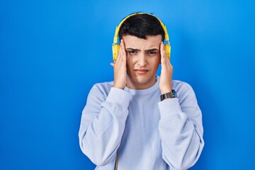 Poster - Non binary person listening to music using headphones with hand on head, headache because stress. suffering migraine.