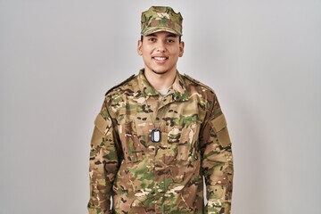 Young arab man wearing camouflage army uniform with a happy and cool smile on face. lucky person.