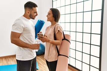 Sticker - Latin man and woman couple wearing sportswear using smartphone at sport center