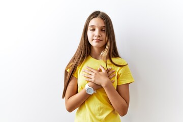 Sticker - Young brunette teenager standing together over isolated background smiling with hands on chest with closed eyes and grateful gesture on face. health concept.