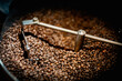 Close up machine spatula with brown arabica coffee beans near special equipment. Factory concept.