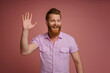 Ginger white man with beard smiling and waving hand at camera