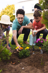 Caucasian family spending time together in the garden, planting