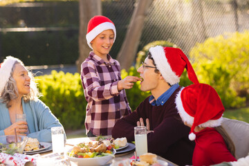 Wall Mural - Caucasian family spending time together and having christmas tree in the garden