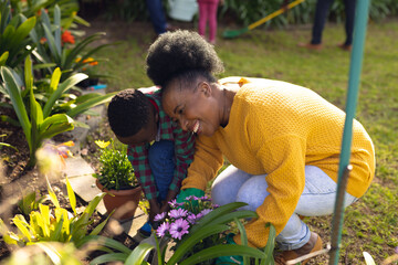 african american mother and son spending time together in the garden and gardening