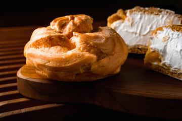 Wall Mural - cream puff, a pastry filled with white cream, dark photography