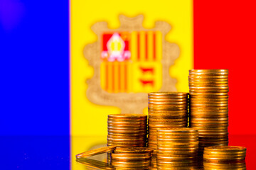 A stack of gold coins on the background of the flag of Andorra. Country economy concept