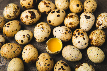 Quail eggs on black texture background. Whole and broken quail eggs. Natural products. Place for text. Fresh quail eggs. Protein. Calcium.