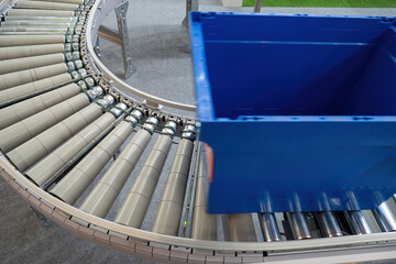 Poster - Fulfillment business. Empty blue box on conveyor. Automation Fulfillment Processor. Box for small packages on conveyor. Equipment for fulfillment company. Automated order processing. Art focus.