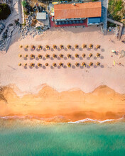 Aerial View Of Parasols On The Beach With No People In Summertime In The Algarve Region, Portugal.