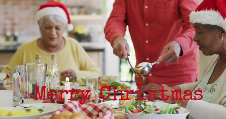 Canvas Print - Animation of christmas greetings text over diverse friends at christmas meal table