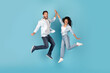 © Prostock-studio - Excited cheerful millennial caucasian and arabic couple jumping in air, give high five, on free space