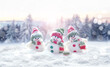 Merry Christmas and happy New Year greeting card with copy space. Three snowmen standing in snow. Christmas landscape. Winter background.