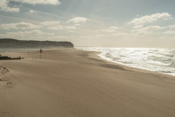 Wall Mural - Beautiful golden sand with bright sun reflection in ocean water at Praia da Foz do Arelho in Portugal in summer