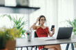 © StockPhotoPro - Young woman sitting at desk and using her smartphone