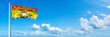 New Brunswick - Canada flag waving on a blue sky in beautiful clouds - Horizontal banner
