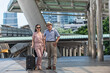 © ENGINEER - STUDIO - Senior couple tourists traveling city.Happy senior couple tourists with luggage in the city