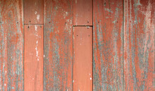 The Orange Wooden Wall With Some Peeling Paint Due To Aging.