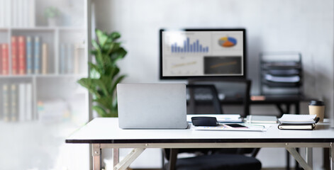 Wall Mural - Laptop Computer, Minimal background image of inviting empty workplace with white desk and succulent plant in foreground, copy space after working hours
