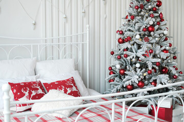 Wall Mural - Christmas bedroom decor. Christmas tree with gifts stands next to the double bed