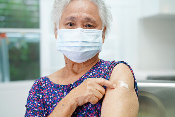 Asian elder senior woman patient getting coronavirus vaccine.