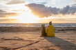 a german boxer dog sitting on the seashore during sunset with owner blonde girl team partner friend sweden melbystrand