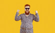 Yes, great success. Funny emotional fat guy in crazy animal print PJs celebrating and having fun. Overweight man wearing leopard pajamas and cool funky glasses feels very happy, excited and confident