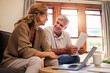 © Nina Lawrenson/peopleimages.com - Laptop, senior couple and retirement planning with documents while sitting on sofa in the living room. Finance, budget and happy elderly man and woman working on pension fund, mortgage bills and debt