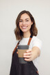 © Martin Villadsen - Portrait of beautiful young barista woman looking in camera and smiling, while holding a to-go coffee in hand. Isolated on white background. Concept: You want coffee? Grab and go