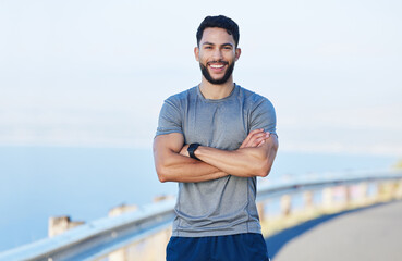 man athlete, healthy and with cross arms, smile and stand happy outdoor for workout, warm up and wel