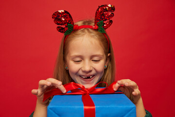 Wall Mural - Smiling funny child (kid, girl) in Reindeer Hairband