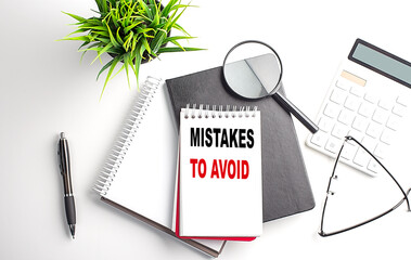 Poster - Text MISTAKES TO AVOID on notebook with office tools on white background