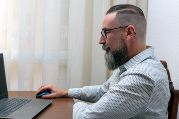 hipster bearded man working with laptop computer at home