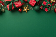 New Year Concept. Top View Photo Of Red Gift Boxes With Green Ribbon Bows Baubles Gold Star Ornaments Mistletoe Berries And Pine Branches In Snow On Isolated Green Background With Empty Space