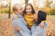© Strelciuc - Young family of three posing in the autumn park: mother, dad and daughter having fun walking in the summer park. Autumn forest. Parent, child. Outdoor lifestyle