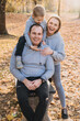 © Strelciuc - Caucasian mother, father and son posing together in the autumn park, smiling to the camera. Family, childhood, real people lifestyle concept. Healthy lifestyle
