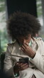 © Marco - A black woman using phone. An African American girl with with Afro hair consuming content online looking at smartphone device screen with serious expression SS