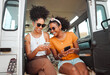 © K Abrahams/peopleimages.com - Women, road trip or phone for social media, gps location or map app for safari game drive or summer travel. Smile, happy or bonding friends with 5g mobile technology in camper van in nature landscape