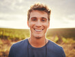 © S Fanti/peopleimages.com - Happy, face and nature with a man at sunset, enjoying freedom with a smile and standing on a field of grass in the day. Travel, vacation and morning with the portrait of a handsome young male outside