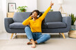 © Xavier Lorenzo - Happy african woman singing in hand microphone while relaxing at home - Happiness lifestyle concept