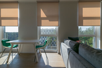 Poster - Roller blinds in the interior. Roller shades automatic on large windows to the floor in the interior. Armchairs with green pillows in the kitchen near windows with motorized roller blinds. Sunny day. 
