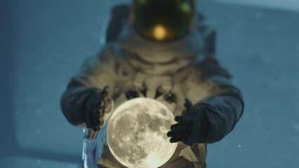 Wall Mural - Close up of and astronaut in space suit holding and dropping the moon Dark sci-fi interior. 3D animation. 
