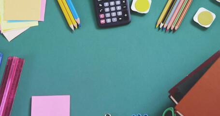 Canvas Print - Overhead view of multicolored pencils with calculator, ruler, sticky notes and books on blue table