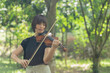 Beautiful woman hold violin on nature view background, in emotion feeling happy.