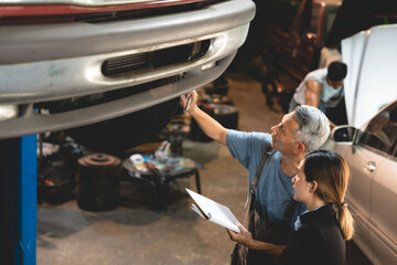 professional male technician mechanic man working to repair maintenance automobile at auto car garage service, talking with vehicle owner client about workshop job, automotive engine business shop