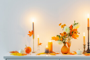 Wall Mural - beautiful autumn home decor with burning candles in white interior